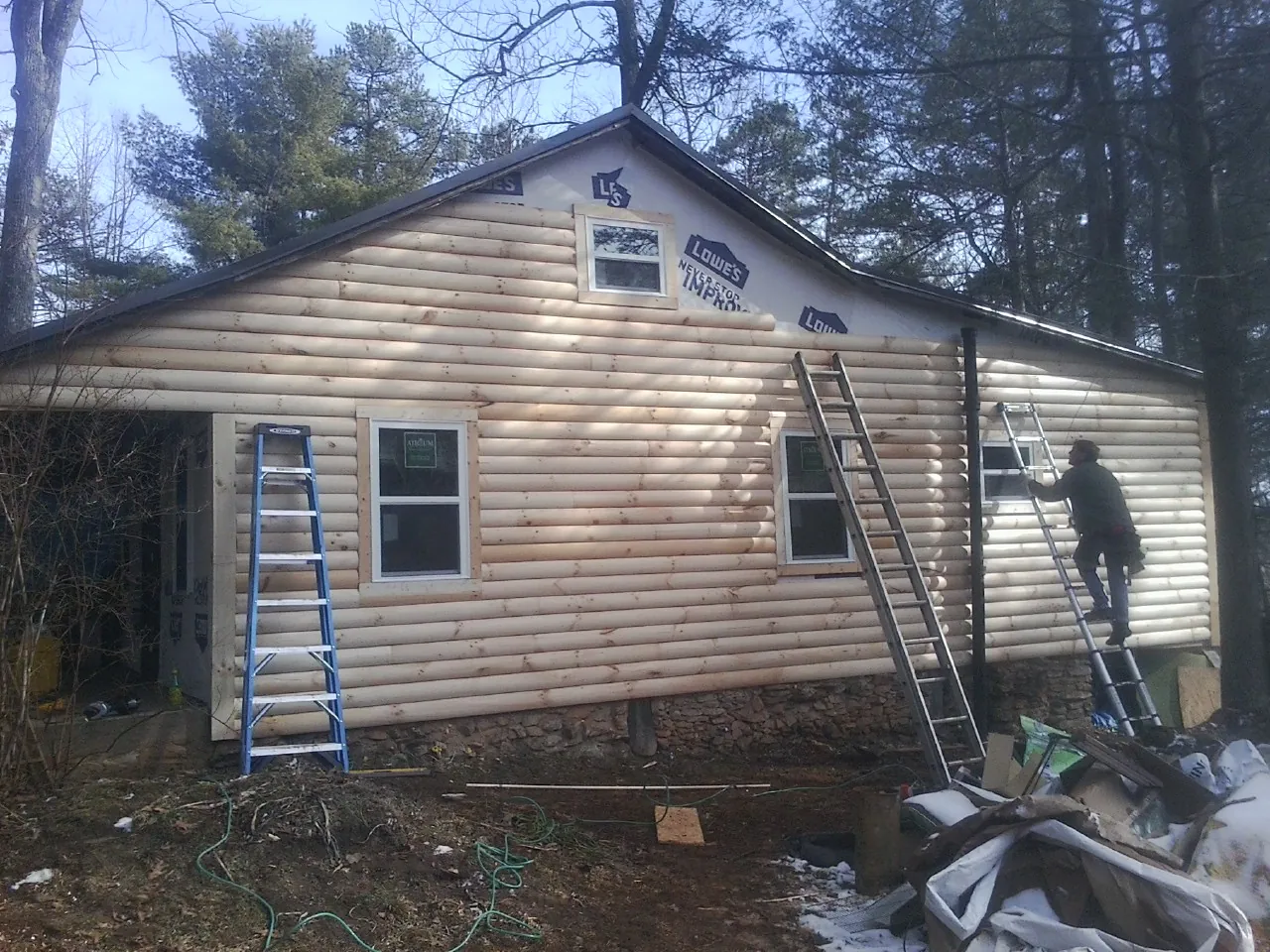 Ladders set against fresh log siding during an exterior remodel in Neptune Beach