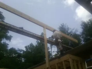 Carpenter setting a ridge beam over a new addition frame — Ice Dam Removal by Roofing Brothers in Neptune Beach