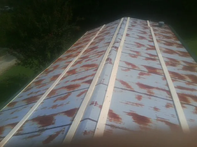 Rusted metal roof panels with new wood purlins before replacement — Storm Damage Roof Repair in Neptune Beach by Roofing Brothers
