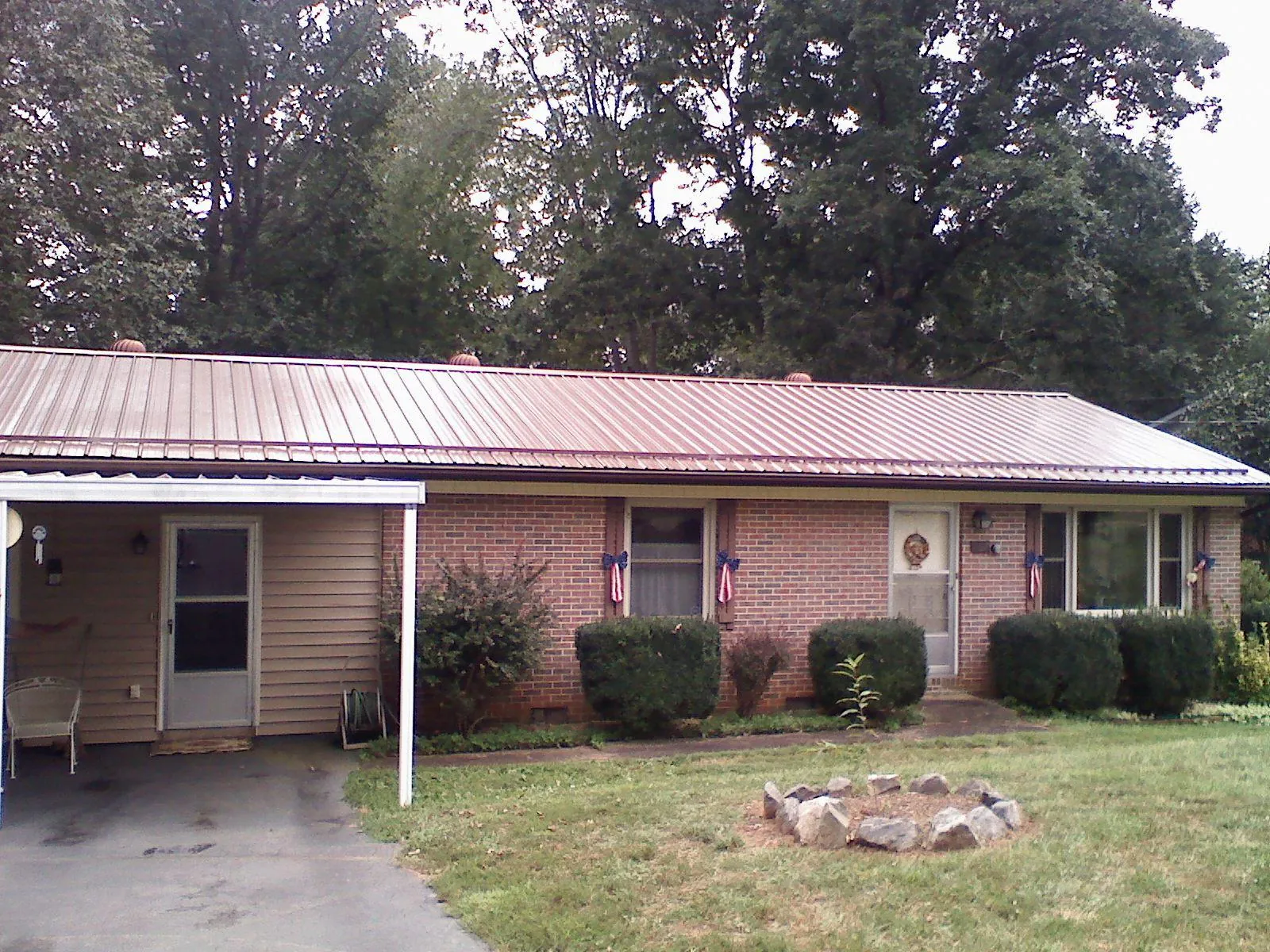 Bronze metal roof and carport on a brick ranch home — Roof Repair work by our crew in Neptune Beach